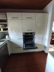 a kitchen with white cabinets and an oven at Schöner Wohnen in Rheinau