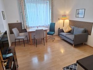 a living room with a couch and a table and chairs at Haus Marisa Ferienwohnungen in Aflenz Kurort