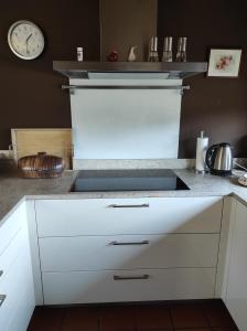 a kitchen with a sink and a clock on the wall at Schöner Wohnen in Rheinau
