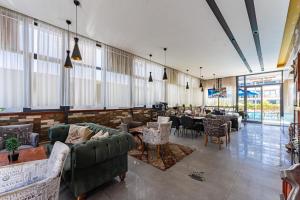 a restaurant with couches and tables and chairs at Bliss Residance in Altınkum