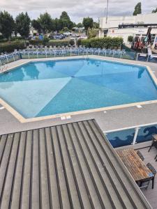 a large swimming pool with chairs and a bench at Willerby Escapes in Lytchett Minster