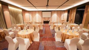 a banquet hall with tables and chairs and a podium at 7 Apple Hotel Visakhapatnam in Visakhapatnam