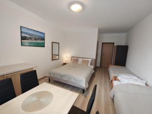 a room with two beds and a table in it at Pogodna 3B in Mielno