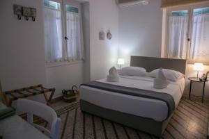 ein Schlafzimmer mit einem großen Bett mit weißen Laken und Kissen in der Unterkunft Aerides Studios in Methana