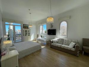a bedroom with a bed and a couch and a tv at Olympia Sozopol in Sozopol