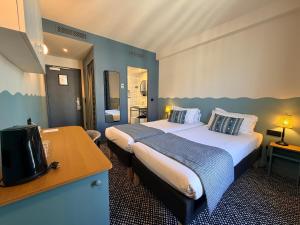 a hotel room with two beds and a television at Hotel Berne Opera in Paris