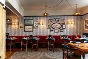 a restaurant with tables and chairs and a red couch at The Swan in Arundel
