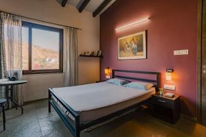 a bedroom with a bed and a window at Nivaant Villa by StayAtlas in Igatpuri