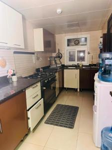 a large kitchen with a stove and a refrigerator at شقة كبيرة مؤثثة بالكامل in Salalah