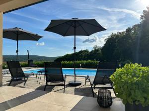 a group of chairs and umbrellas next to a pool at Villa Olealis in Zatka Čepić