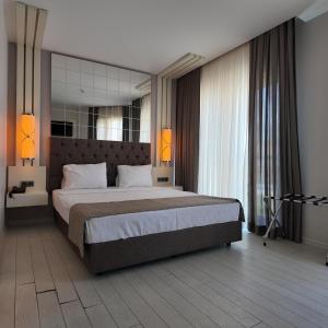 a bedroom with a large bed and a mirror at Çözel Sare Hotel in Güzelçamlı +40 photos