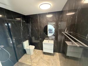 ein Badezimmer mit Spiegel, Waschbecken und Toilette in der Unterkunft Guben Wohnungen Sunny 2 in Guben + 2 Fotos