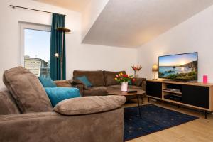 a living room with a couch and a tv at Ferienhaus Alisch Fewo 2 in Warnemünde