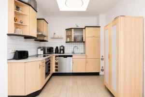 a large kitchen with wooden cabinets and appliances at Ferienhaus Alisch Fewo 2 in Warnemünde