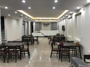 a dining room with tables and chairs and a stage at Flaco Hostel and Booking Office in Sapa