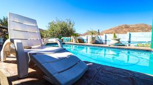 a white chair sitting next to a swimming pool at Home Sweet Home in Springbok