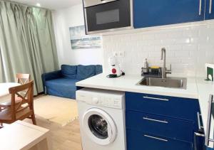 a kitchen with a sink and a washing machine at Casa na Aldeia in Melides