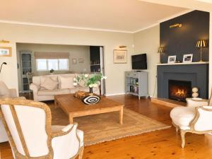 a living room with a couch and a fireplace at Amazing View Villa, Sleeps 9 in Gordonʼs Bay +29 photos