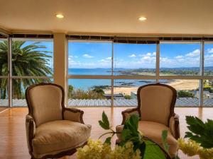 two chairs in a room with a view of the ocean at Amazing View Villa, Sleeps 9 in Gordonʼs Bay