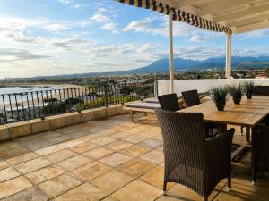 an outdoor patio with a wooden table and chairs at Amazing View Villa, Sleeps 9 in Gordonʼs Bay