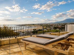 a balcony with a bench and a view of the water at Amazing View Villa, Sleeps 9 in Gordonʼs Bay