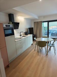 a kitchen and dining room with a table and a table and chairs at Chez EdGare in Liège