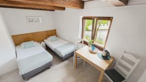 a room with two beds and a table and a mirror at Pokoje Gościnne w Spichlerzu in Ustka