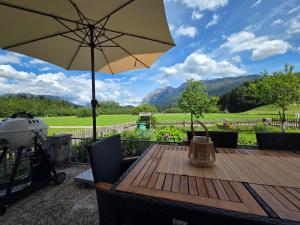 a wooden table with an umbrella on a patio at Ferienhaus DaPfusterer in Bad Mitterndorf