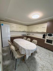 a kitchen with a white table and chairs in it at Vila Lena S in Cahul