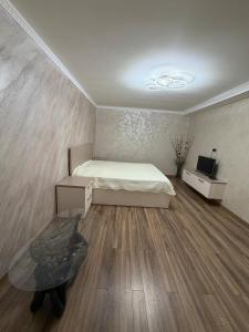 a bedroom with a bed and a table and a tv at Vila Lena S in Cahul