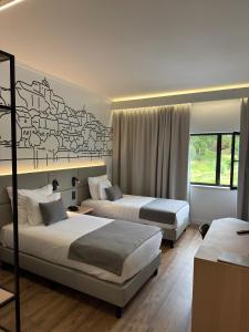 a hotel room with two beds and a window at Hotel Lara in Valença