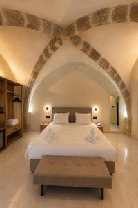 a bedroom with a large white bed with an archway at The Wine Suites in Rhodes Town