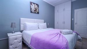 a bedroom with a bed with a purple blanket on it at Home Sweet Home in Springbok +22 photos