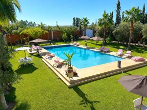 an overhead view of a swimming pool with chairs and umbrellas at Palais Bohemia in El Rhechat