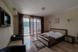 a bedroom with a bed and a large window at Casa Aless Eselnita Adults Only 14 plus in Eşelniţa