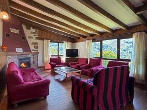 a living room with purple chairs and a fireplace at Casa Rural Istikot in Errazu