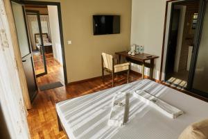 a bedroom with a bed and a table with a television at Echoes of forest in Andasibe