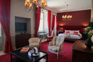 a hotel room with a bed and a table and chairs at Chateau De Germigney in Port-Lesney