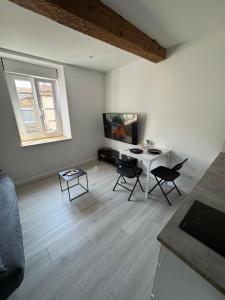 a living room with a table and chairs at Les Perles de Limoux - Centre Clim Wifi Parking Gratuit in Limoux