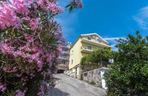a building with pink flowers on the side of a road at Garden Terrace Apartment in Igalo