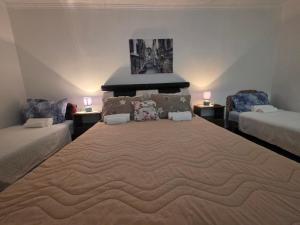 a large bed in a room with two beds at Garden Terrace Apartment in Igalo