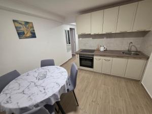 a kitchen with a table and chairs and a sink at Garden Terrace Apartment in Igalo +9 photos