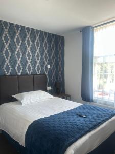 a bedroom with a large bed with a blue blanket at The Hunt Lodge in Leighton Buzzard