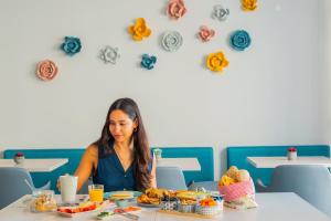 a woman sitting at a table eating food at Boavista Guest House in Porto