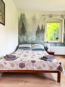 a bedroom with a bed with a painting on the wall at Przytulne Siedlisko in Jugowice