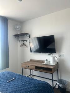 a bedroom with a bed and a desk with a tv at The Hunt Lodge in Leighton Buzzard
