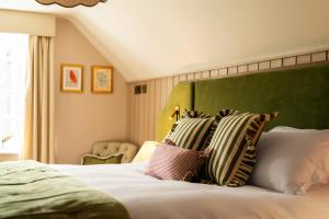 a bed with a green headboard and pillows on it at The Swan in Arundel +82 photos