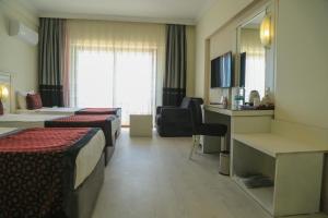 a hotel room with two beds and a desk at Casa Fora Beach Resort Hotel - Spa & Aqua park - All Inclusive Plus Concept in Belek