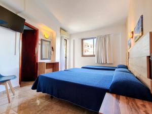 a bedroom with a blue bed and a window at Hostal Horizonte in San Antonio +40 photos