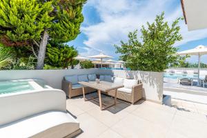 a patio with a table and chairs and a pool at Haris Hotel by Diomedes Group in Hanioti